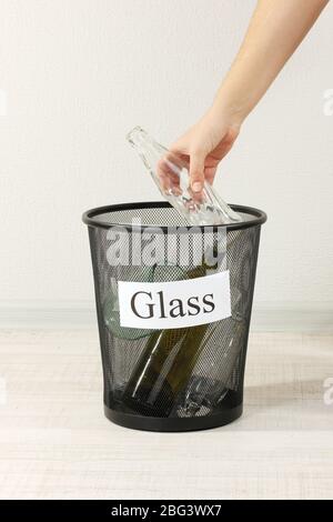 Assorted trash in bucket on room background Stock Photo