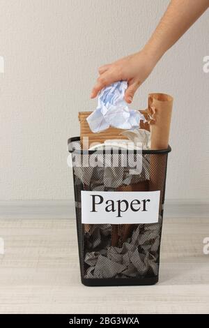 Assorted trash in bucket on room background Stock Photo