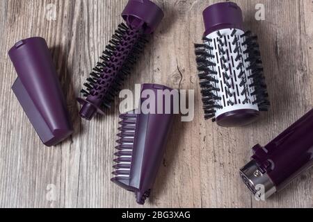 Set of hair dryer attachments on a wooden background. Curling iron, hair straightener. Hot styling, boar bristles, hair care. Beauty salon, styling, h Stock Photo