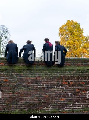 Eton, Windsor, Berkshire, UK.  20th November, 2010. Eton College boys sit on top of a high wall built in 1717 next to the Eton College playing fields as they watch their fellow schoolboys compete in The Wall Game. The first recorded Wall Game was in 1766. Eton College is a fee paying public school attended by many UK politicians including Boris Johnson and David Cameron. Prince William and Prince Harry also attended Eton College. Credit: Maureen McLean/Alamy Stock Photo