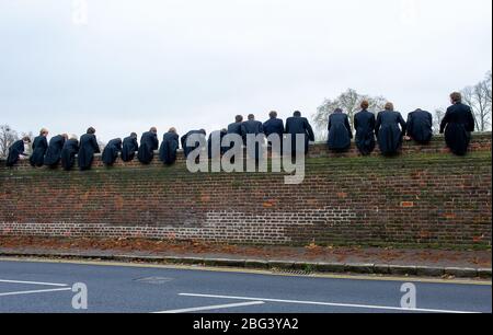 Eton, Windsor, Berkshire, UK.  20th November, 2010. Eton College boys sit on top of a high wall built in 1717 next to the Eton College playing fields as they watch their fellow schoolboys compete in The Wall Game. The first recorded Wall Game was in 1766. Eton College is a fee paying public school attended by many UK politicians including Boris Johnson and David Cameron. Prince William and Prince Harry also attended Eton College. Credit: Maureen McLean/Alamy Stock Photo