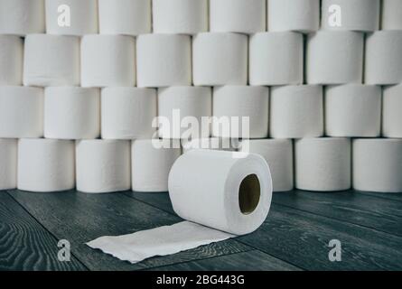 Roll of toilet paper in front of a stack of toilet rolls Stock Photo