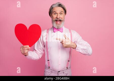 Portrait of his he nice attractive imposing ecstatic cheerful cheery grey-haired man holding in hands demonstrating big large heart soulmate isolated Stock Photo