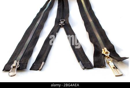 two closed and one opened metal  zippers closeup on white background Stock Photo