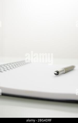 Ink pen lying on opened spiral notebook. Empty space ready for your text. Stock Photo