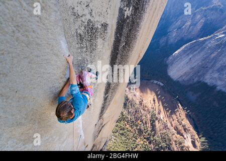 Climbing holding on sideway in crazy position to free climb the Nose