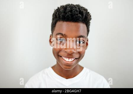 Smiling preteen black boy wearing white tshirt Stock Photo