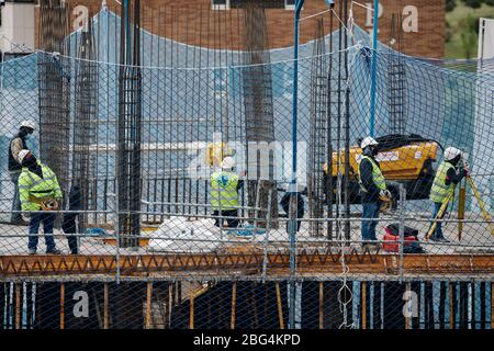 April, 15 2020, in Madrid, Spain some colleagues from the construction industry are working together on the construction of a building Stock Photo