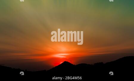 Long exposure colorful sunset over the mountains. Dramatic tropical mountain forest and orange sky sunset. Spectacular sunrise sky over the mountains Stock Photo
