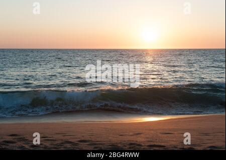 Sun setting over Pacific Ocean at beach in Mexico Stock Photo