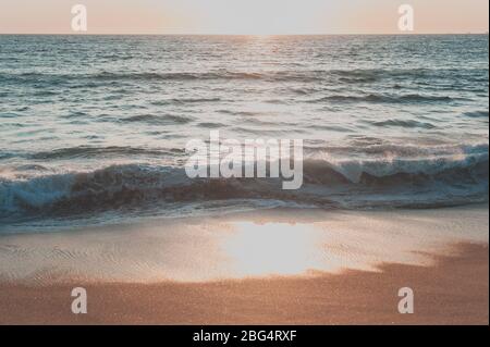 Waves crashing on shore at sunset in Mexico Stock Photo