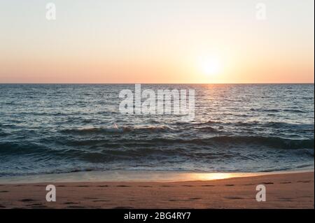 Sun setting over Pacific Ocean at beach in Mexico Stock Photo