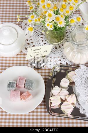 Table setting with chamomiles on checkered tablecloth Stock Photo