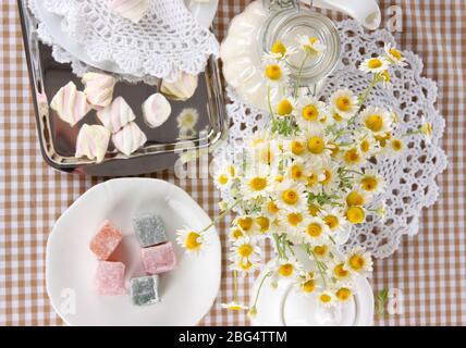 Table setting with chamomiles on checkered tablecloth Stock Photo