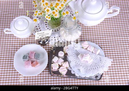 Table setting with chamomiles on checkered tablecloth Stock Photo