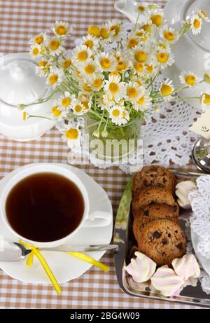 Table setting with chamomiles on checkered tablecloth Stock Photo