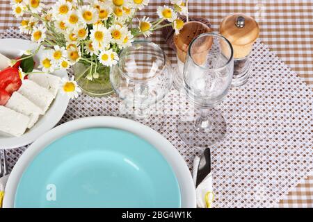 Table setting with chamomiles on checkered tablecloth Stock Photo
