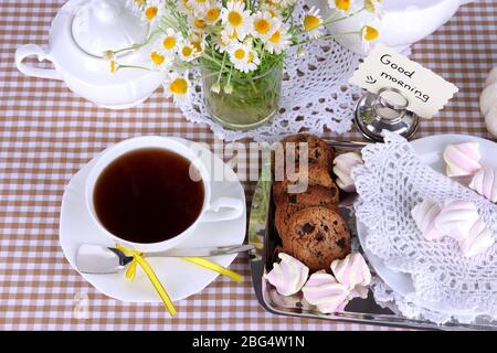 Table setting with chamomiles on checkered tablecloth Stock Photo