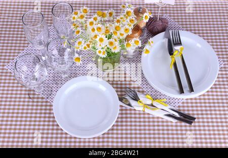 Table setting with chamomiles on checkered tablecloth Stock Photo