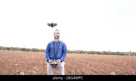 young man prepares the battery of his drone in the field to go fly Stock Photo