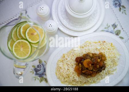 A bowl of white ceramic salt and pepper. Shah pilaf. Khan pilaf in a pita. Black pepper in a white ceramic pot . There is meat and plum chestnuts on Stock Photo