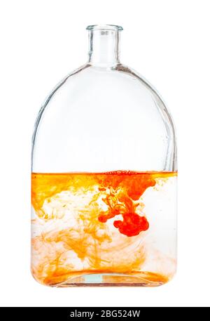 orange watercolors dissolving in water in glass flask isolated on white background Stock Photo