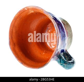 overturned empty handmade cup from red clay isolated on white background Stock Photo