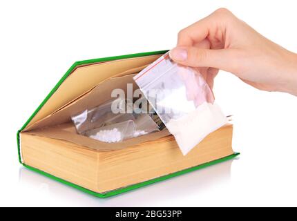 Hand holding narcotics near book-hiding place isolated on white Stock Photo