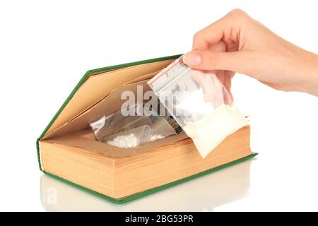 Hand holding narcotics near book-hiding place isolated on white Stock Photo