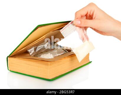 Hand holding narcotics near book-hiding place isolated on white Stock Photo