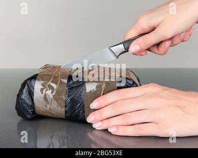 Packages of narcotics in hand on gray background Stock Photo