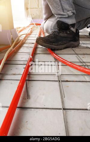 Piping installation of the heating system, the master attaches the pipes to the foam.2020 Stock Photo
