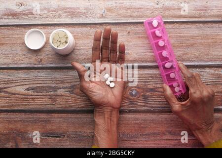 Elderly woman taking medicine from pill box  Stock Photo