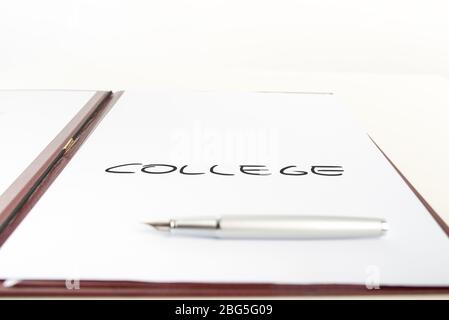 White paper with a College sign placed in an open  leather folder with a pen lying on the paper. Stock Photo