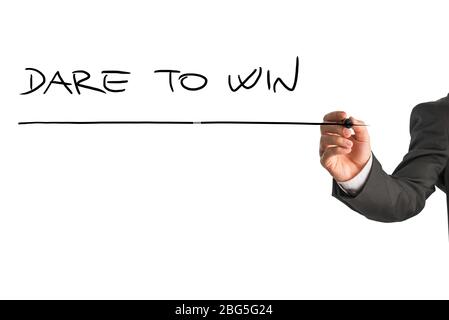 Man writing a business motivational message - Dare to win - on a virtual interface or screen with a marker as a sign of encouragement, with copyspace Stock Photo