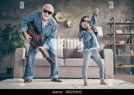 Photo of two people funky grandpa play guitar small nice granddaughter mic singing cool style sun specs denim clothes repetition school concert stay Stock Photo