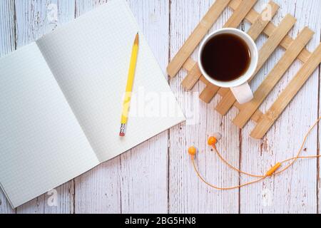 high angle view of notepad, pencil, tea and headphone  Stock Photo