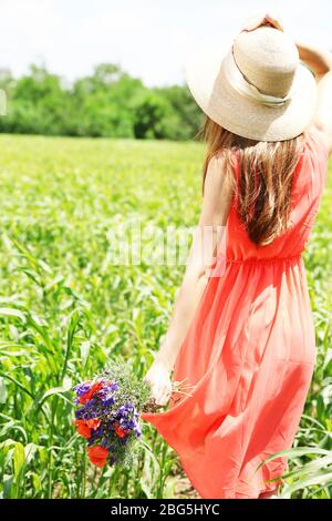 Portrait of beautiful young woman with poppies in the field Stock Photo