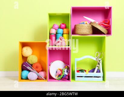 Colorful shelves of different colors with utensils on wall background Stock Photo