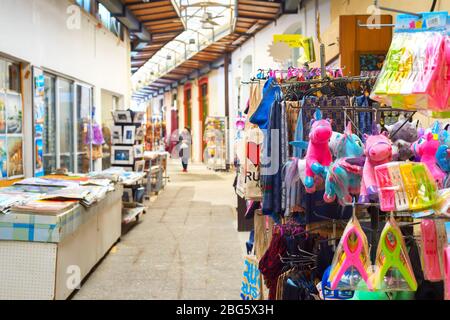 LARNACA, CYPRUS - FEBRUARY 16, 2019: Colorful gifts puppets, kitchen towels on stands at souvenir market in Larnaca touristic downtown Stock Photo