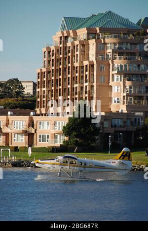 Victoria, Vancouver Island - September 2012: A seaplane about to take off from Victoria harbor, with a waterfront apartment building in the background Stock Photo