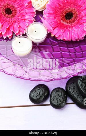 Spa stones, beautiful gerbera flowers and candles on water Stock Photo ...