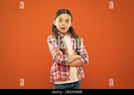 Wondering every day. Upbringing versatile personality. Childhood concept. Girl child stand orange background. Mentally and physically healthy child. Child care and psychology. Wellbeing and health. Stock Photo