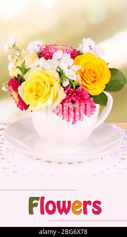 Beautiful bouquet of bright flowers in mug on bright background Stock Photo