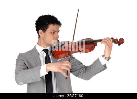 A young handsome man in a gray suit playing the violin, looking concentrated serious, isolated for white background Stock Photo