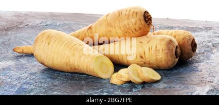 Parsnip root and slices on rustic background. Fresh raw organic vegetable plant Stock Photo