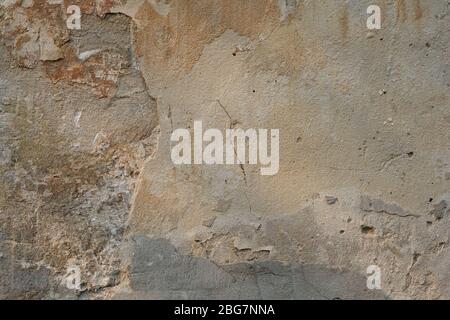 Old peeled cement wall background. Stucco texture on the wall. Cracked Cracked Rough Abstract Surface Stock Photo