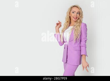 Carefree attractive blonde girl having fun dancing to funny music, woman smiling and looking happy, standing against white background Stock Photo