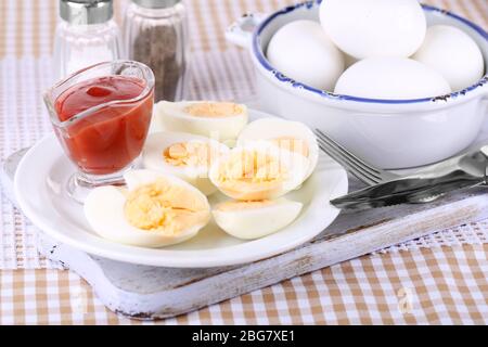 Boiled eggs on wooden board on tablecloth Stock Photo