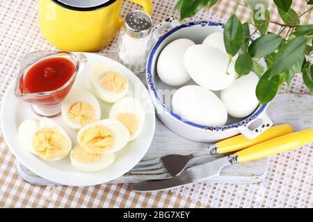 Boiled eggs on wooden board on tablecloth Stock Photo